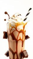 Creamy caramel shake topped with whipped cream and chocolate garnishes in a clear glass photo