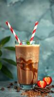 Chocolate milkshake with fresh strawberries and mint served in a tall glass on a blue background photo