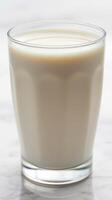 Smooth and creamy glass of milk served on a marble countertop in a cozy kitchen setting photo