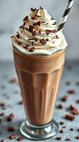 Delicious iced coffee topped with whipped cream and chocolate shavings in a clear glass photo