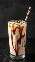 Creamy milkshake with chocolate swirl served in a tall glass on a dark background photo