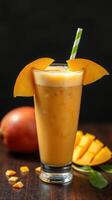 Refreshing mango smoothie served in a tall glass with vibrant fruit garnish on a wooden table photo