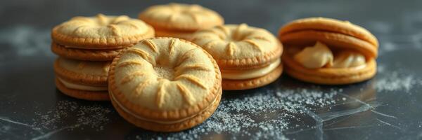 Delicious golden cookies stacked with creamy filling on a dark surface with a sprinkle of sugar photo