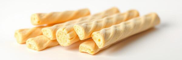 Crispy wands of sweet snack stacked in a neat arrangement on a plain background ready for enjoyment photo