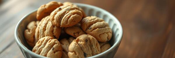 Freshly baked cookies arranged in a rustic bowl on a wooden table for a cozy dessert experience photo