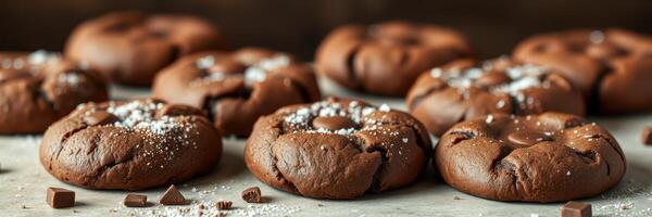 Freshly baked chocolate cookies with powdered sugar on a wooden countertop in a cozy kitchen setting photo