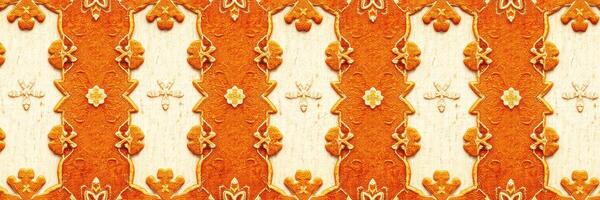 Decorative orange and cream patterned design featuring intricate floral motifs suitable for art and design projects photo