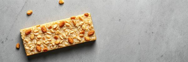 Crunchy snack bar with nuts and grains on a gray background photo
