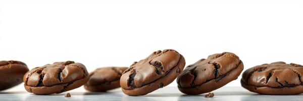 Chocolate cookies arranged on a light wooden surface against a white background photo