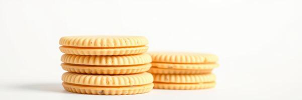 Stacked golden cream-filled cookies on a white background showcasing texture and color contrast in a simple arrangement photo
