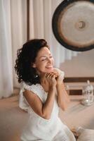 Woman in white clothes with closed eyes sitting in a fitness class. The concept of a women's circle photo