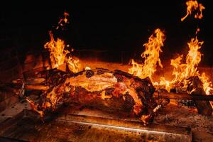 The lamb is cooked entirely on a spit on the fire. Cooking photo