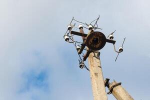 One old concrete street pole with a rusty iron part at the top and cut wires, Installation or dismantling of the power grid. A broken energy pillar photo