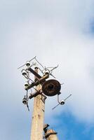 One old concrete street pole with a rusty iron part at the top and cut wires, Installation or dismantling of the power grid. A broken energy pillar photo