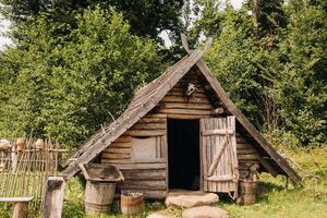Triangular log houses with wooden roofs in an old medieval village photo
