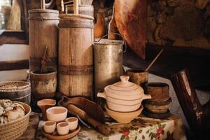 Old wooden barrels and dishes on the table in the village. Rustic antique tableware photo