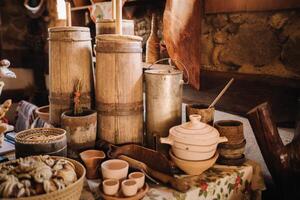 Old wooden barrels and dishes on the table in the village. Rustic antique tableware photo