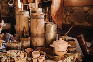Old wooden barrels and dishes on the table in the village. Rustic antique tableware photo