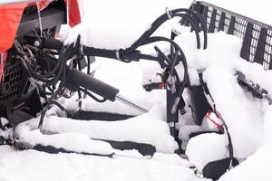 The bucket of a snowplow on tracks, standing in the forest in winter photo