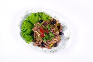 Sliced meat salad with pickled cucumbers and ketchup on an isolated background photo