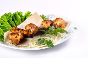 Chicken meat on pita bread with vegetables on a white plate on a white isolated background photo