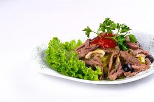 Sliced meat salad with pickled cucumbers and ketchup on an isolated background photo