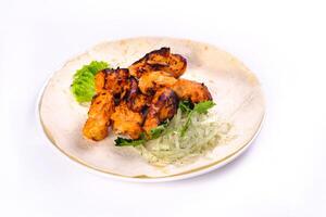 Chicken meat on pita bread with vegetables on a white plate on a white isolated background photo