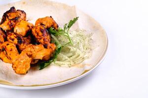 Chicken meat on pita bread with vegetables on a white plate on a white isolated background photo