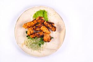 Chicken meat on pita bread with vegetables on a white plate on a white isolated background photo