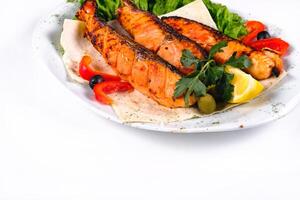 Fried fish with vegetables on a plate on a white isolated background photo