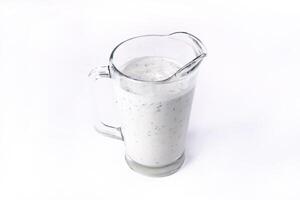 A glass of ayran with dill and parsley, highlighted on a white isolated background. Cold yogurt drink photo