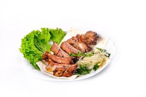 Meat kebab on ribs on lavash with onions and cabbage on a white plate, on an isolated white background photo