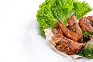 Meat kebab on ribs on lavash with onions and cabbage on a white plate, on an isolated white background photo