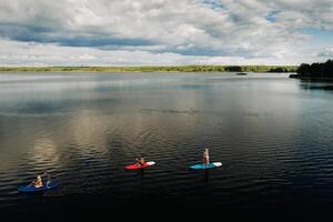 Family spend time together relaxing on sup boards on the lake photo