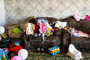 A mess in the room. A lot of things are lying around the apartment. House is in the room photo