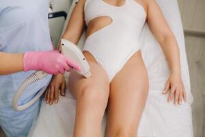 A close-up of the work of a cosmetologist who performs a laser hair removal procedure in the office photo
