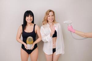 Cactus concept. Unshaven body . One girl is holding a cactus in her hands, and the second girl is holding a razor. Symbol of unshaven body parts photo