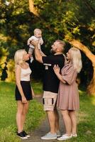 Happy family in the park of four people in the summer in the park in nature photo