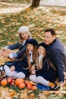 A big family on a picnic in the fall in a nature park. Happy people in the autumn park photo