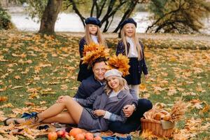 A big family on a picnic in the fall in a nature park. Happy people in the autumn park photo