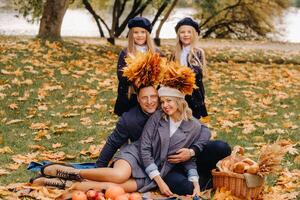 A big family on a picnic in the fall in a nature park. Happy people in the autumn park photo