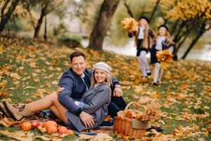 A big family on a picnic in the fall in a nature park. Happy people in the autumn park photo