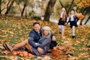 A big family on a picnic in the fall in a nature park. Happy people in the autumn park photo