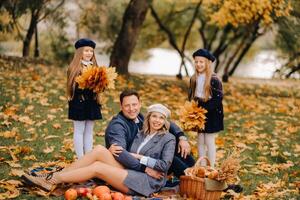 A big family on a picnic in the fall in a nature park. Happy people in the autumn park photo