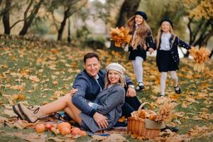 A big family on a picnic in the fall in a nature park. Happy people in the autumn park photo