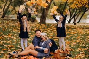 A big family on a picnic in the fall in a nature park. Happy people in the autumn park photo