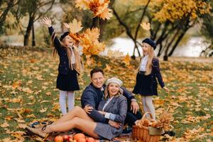A big family on a picnic in the fall in a nature park. Happy people in the autumn park photo