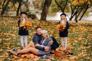 A big family on a picnic in the fall in a nature park. Happy people in the autumn park photo