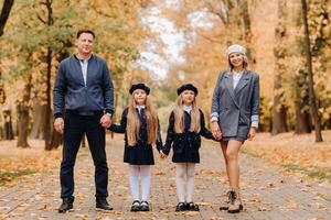 A large family walks in the park in the fall. Happy people in the autumn park photo