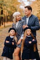 A large family walks in the park in the fall. Happy people in the autumn park photo